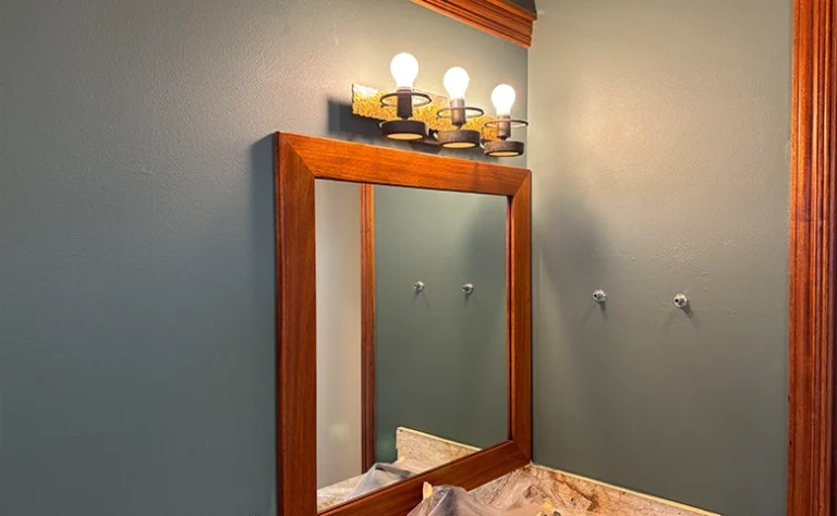 Homeowner using small roller to paint accent wall in a modern bedroom